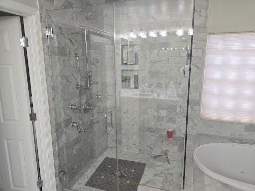 A bathroom with a walk in shower and a bathtub.