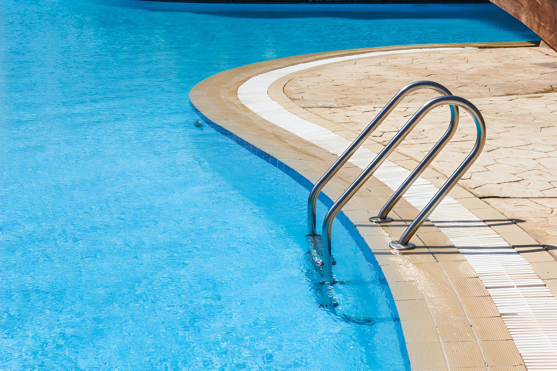 A Swimming Pool With Blue Water With Beige Tiling — Landsborough Pool Supplies & Service in Landsborough, QLD