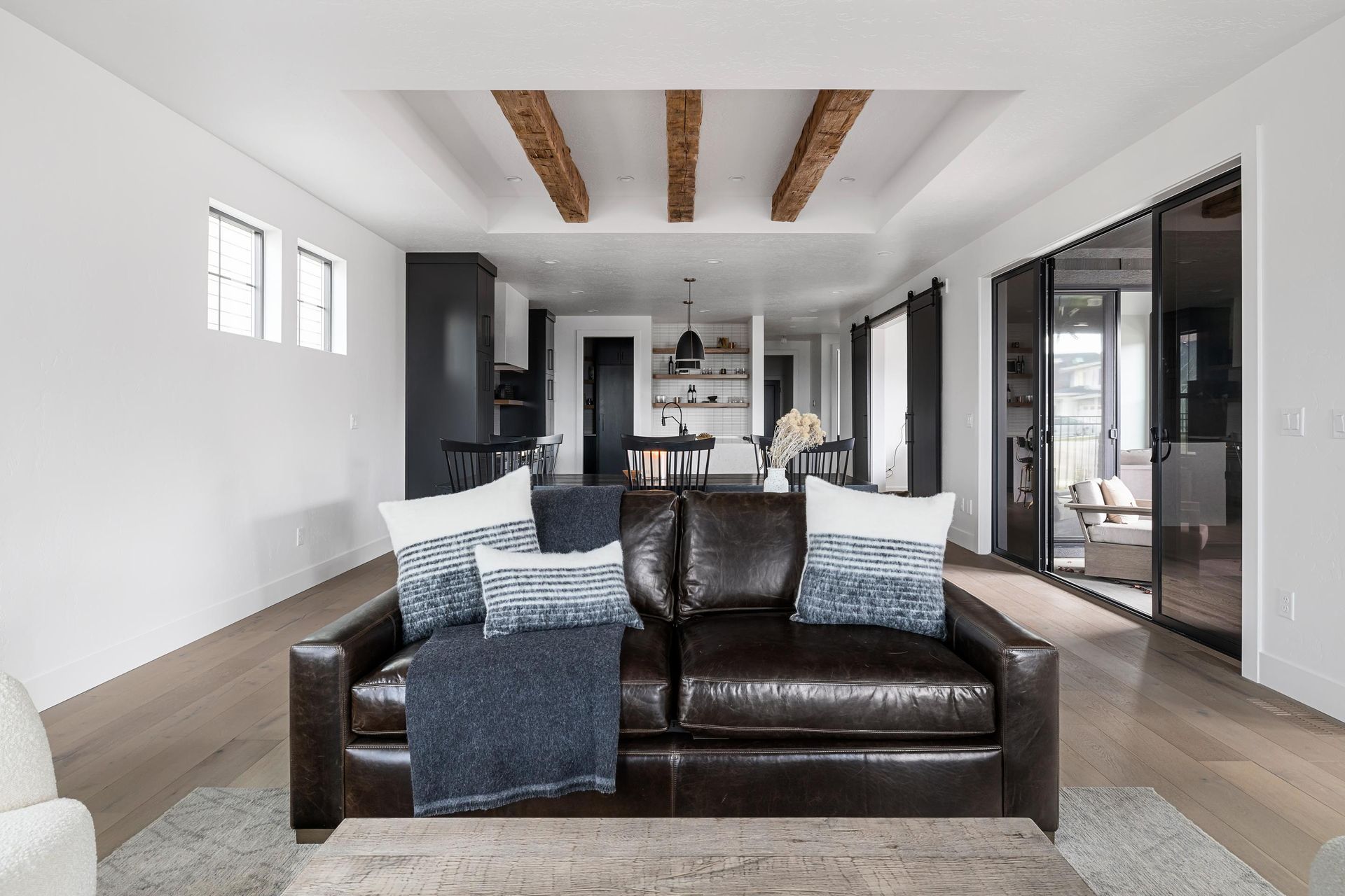 A living room with a brown leather couch and blue and white pillows.