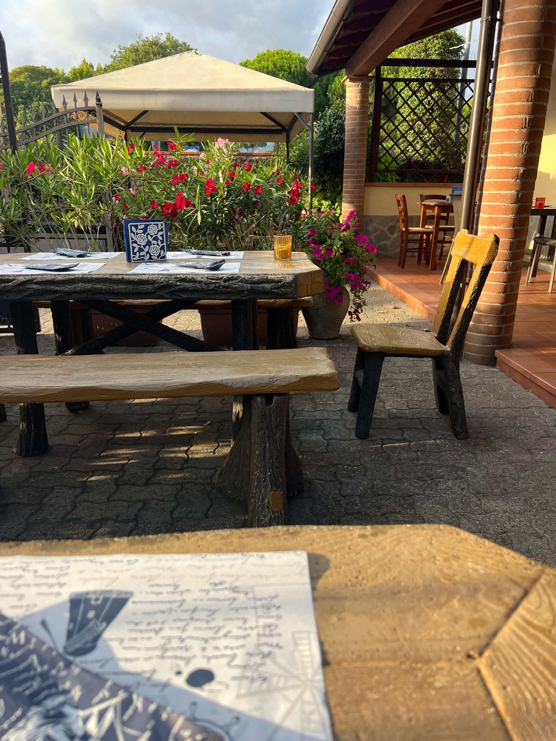 Un patio con tavolo, sedie e fiori sullo sfondo