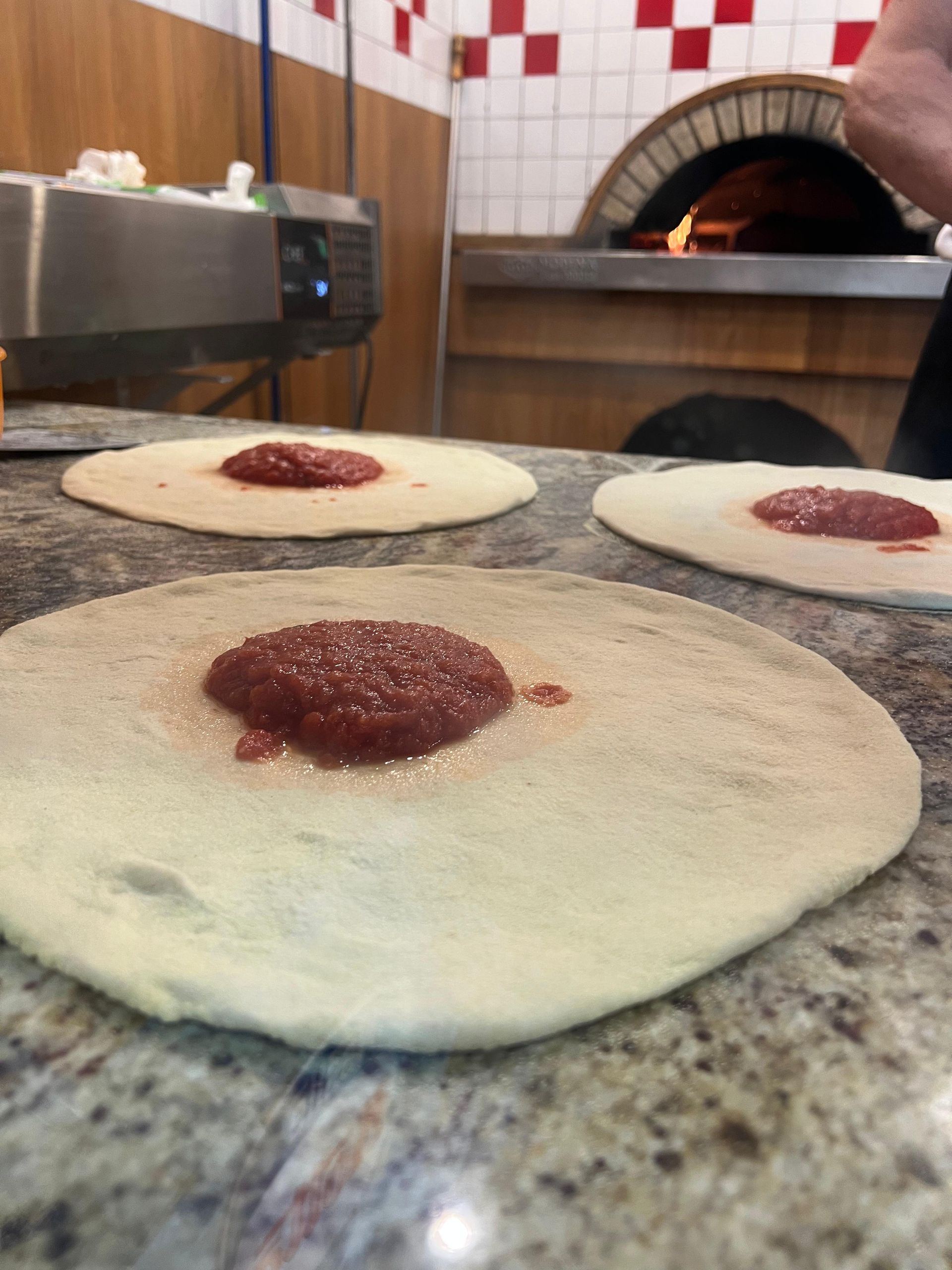Impasto per pizza con salsa sopra su un bancone