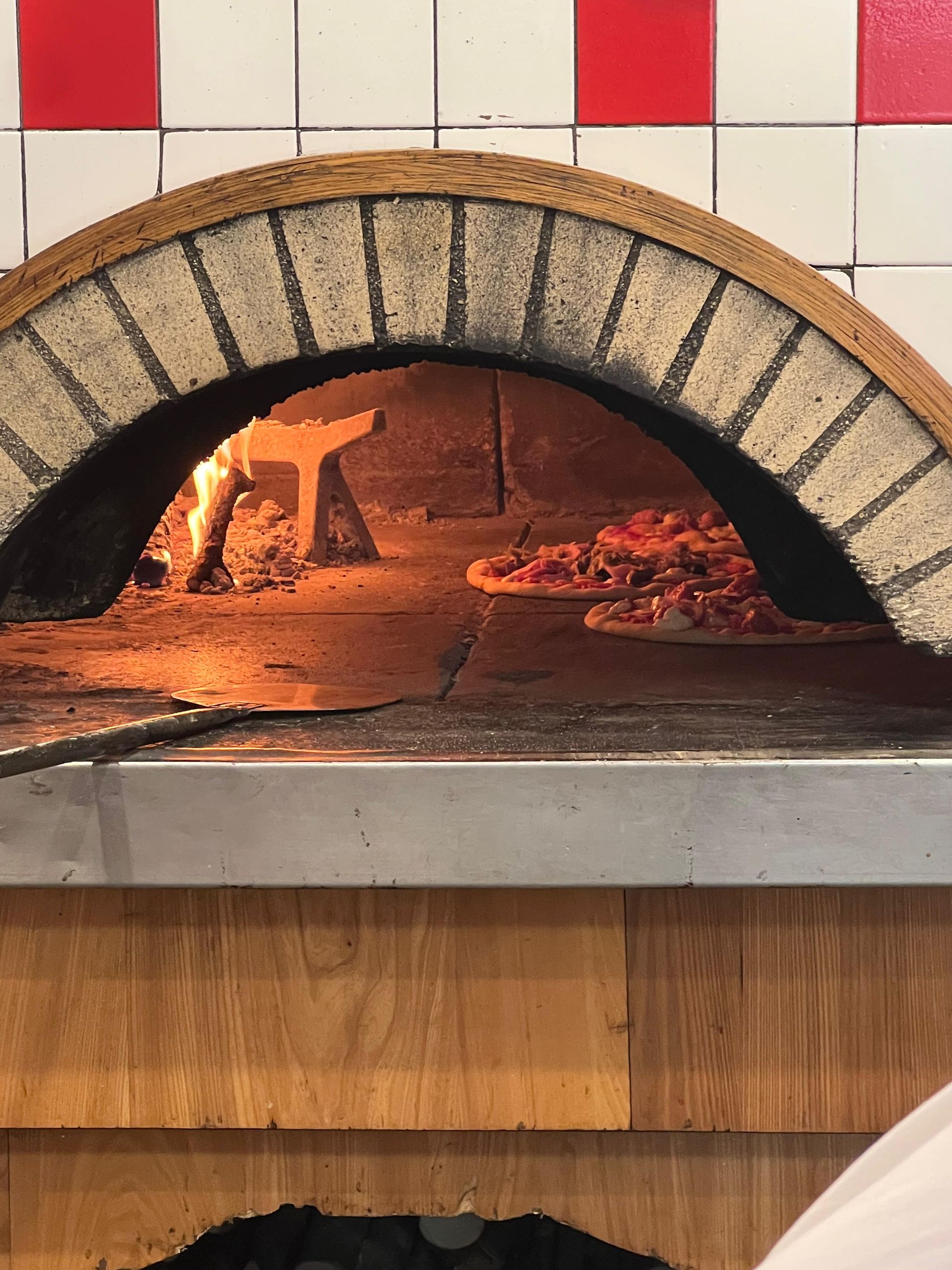 Tre pizze sono appoggiate sul bancone di un ristorante.