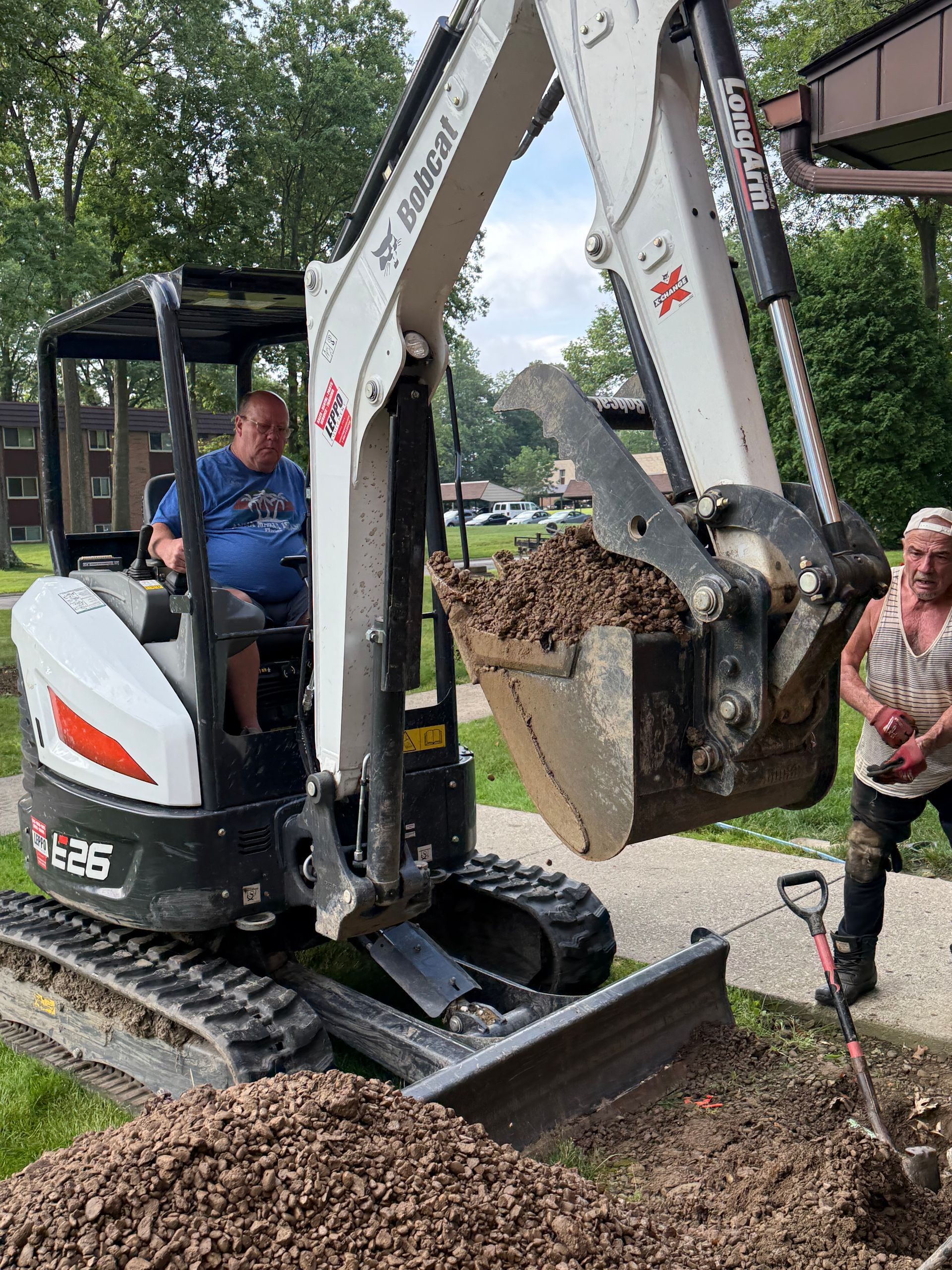 A man is sitting in the driver 's seat of a bobcat excavator.