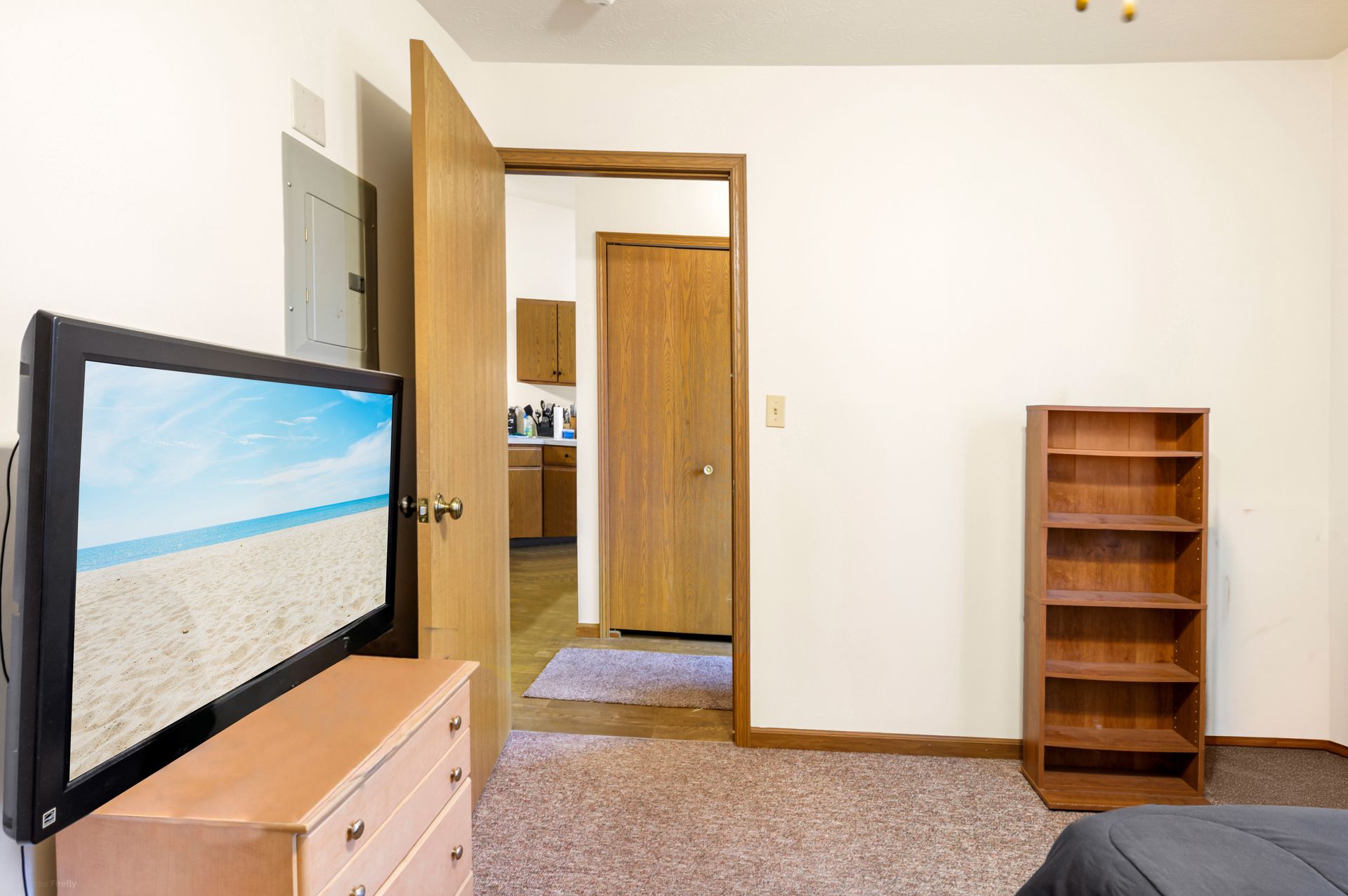 A bedroom with a flat screen tv and a dresser