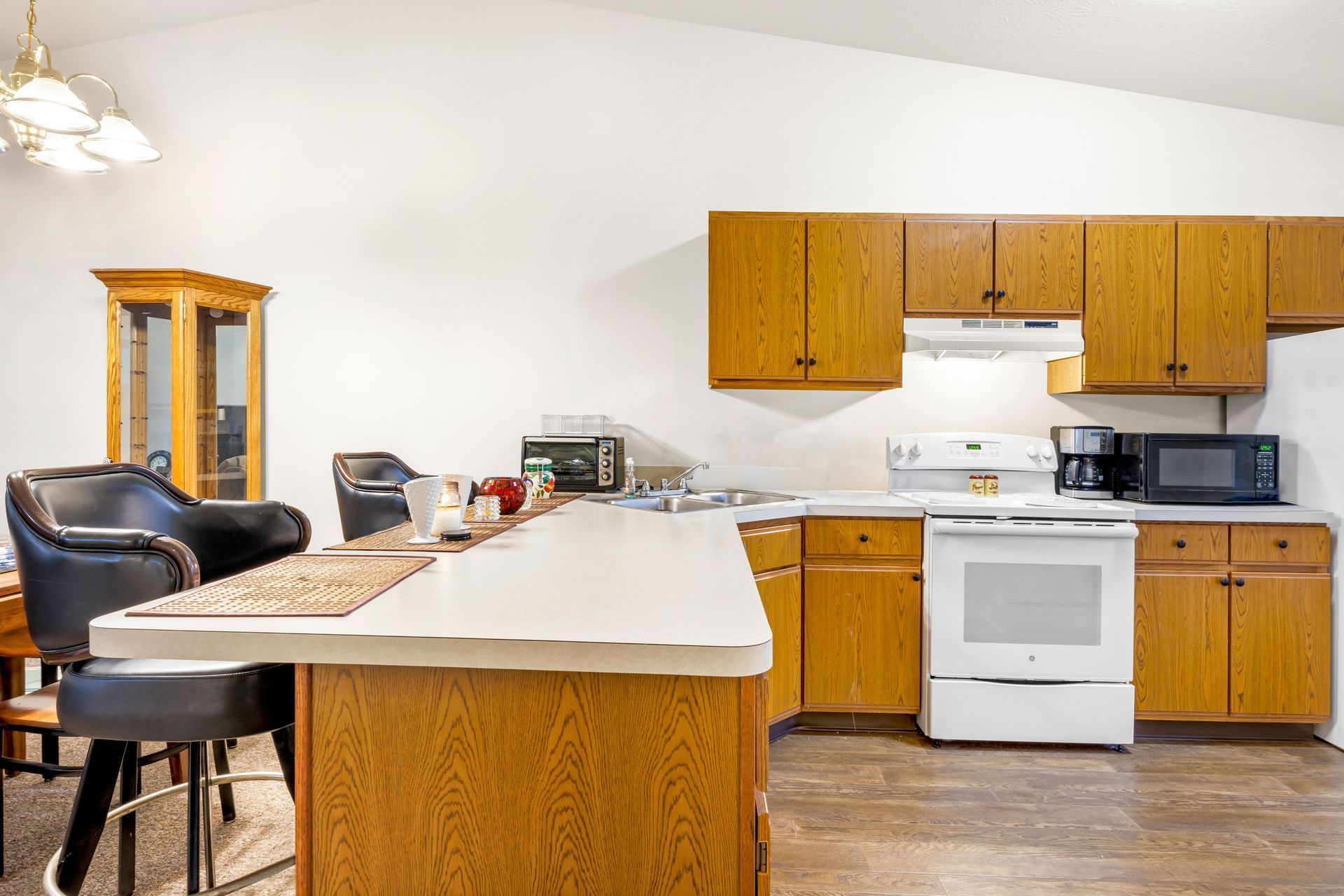 A kitchen with wooden cabinets and a white stove.