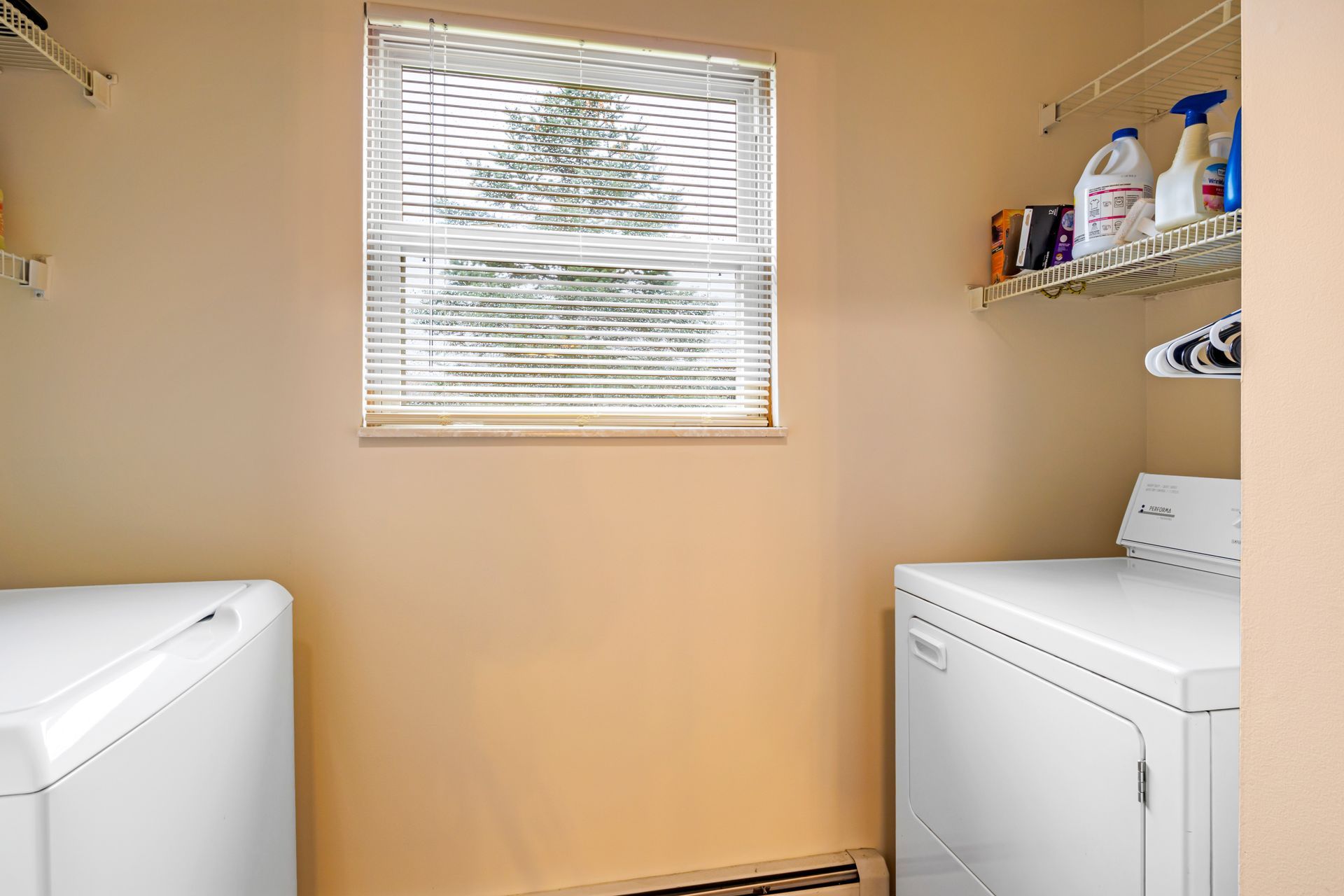 A laundry room with a washer and dryer and a window.