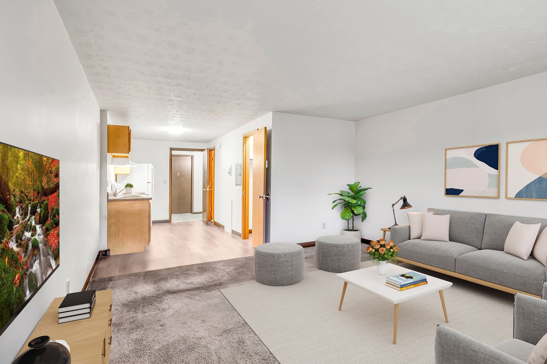 A living room with a couch , chair , coffee table and television.