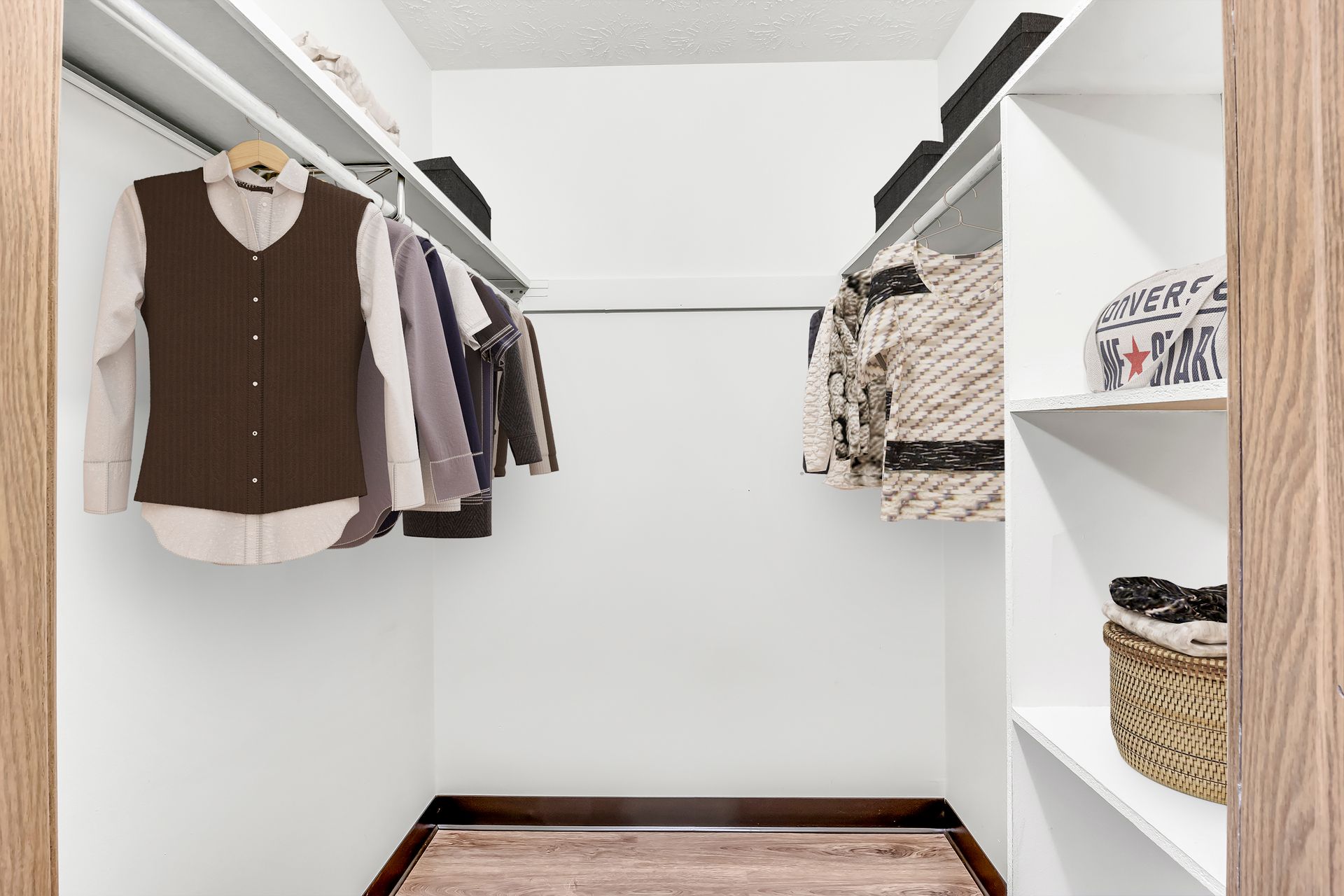 A walk in closet with clothes hanging on racks and shelves.