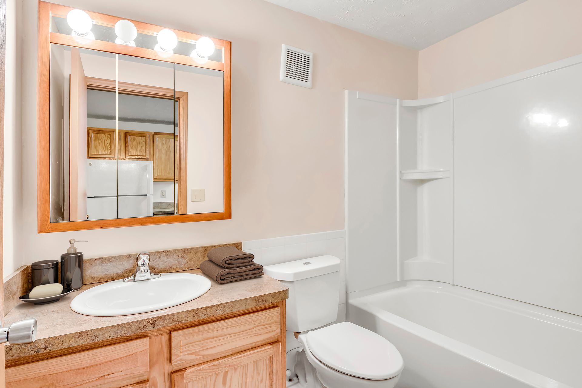 A bathroom with a sink , toilet , bathtub and mirror.