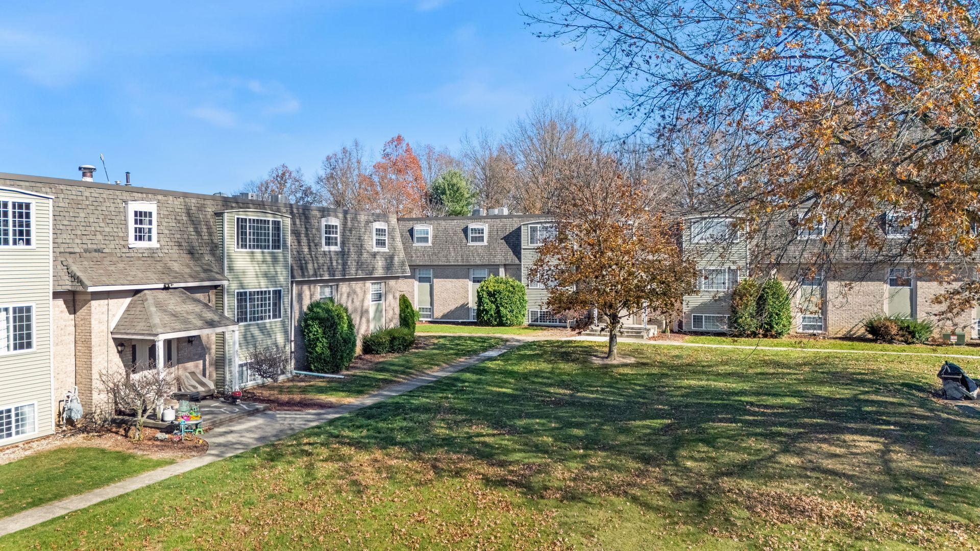 A row of houses with a large lawn in front of them.