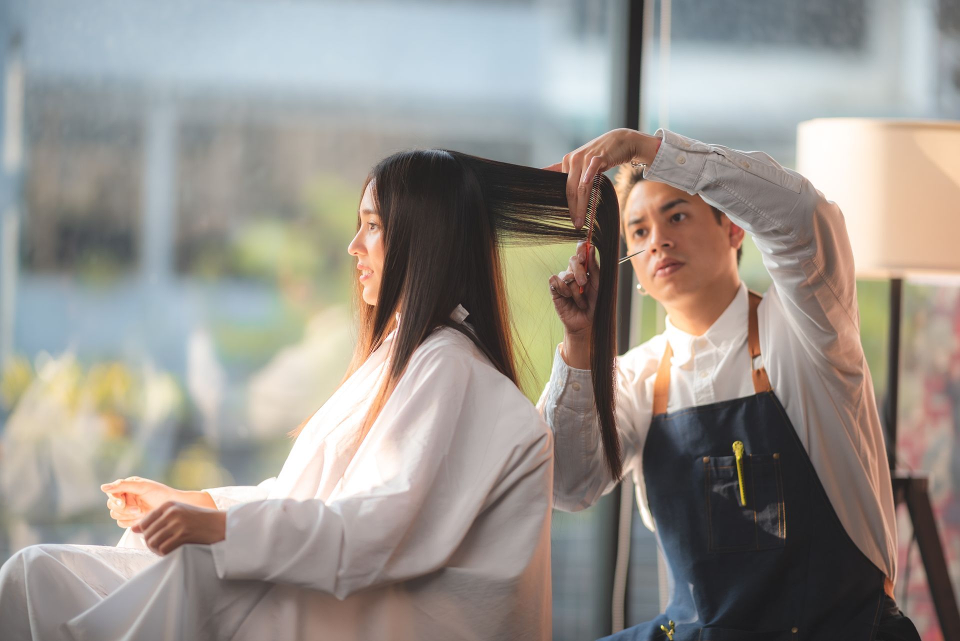 A woman is getting her hair blow dried by a hairdresser.