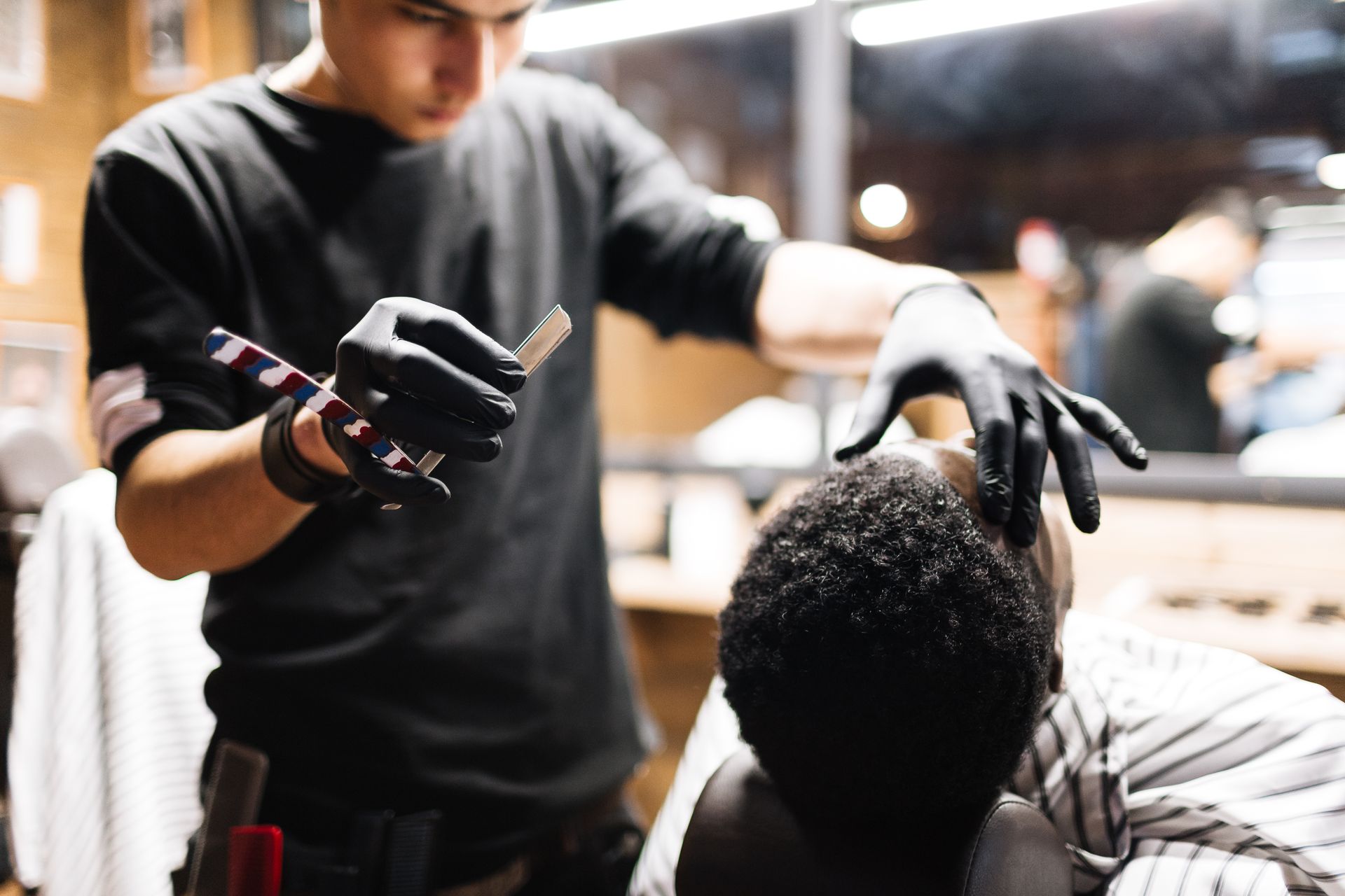A man is getting his hair cut by a barber in a barber shop.