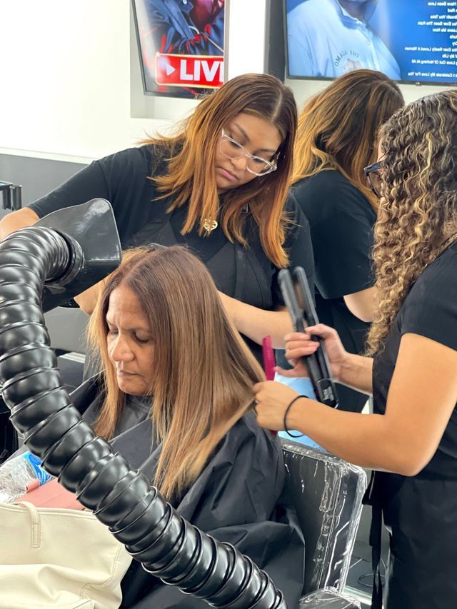 A woman is getting her hair straightened in a salon.