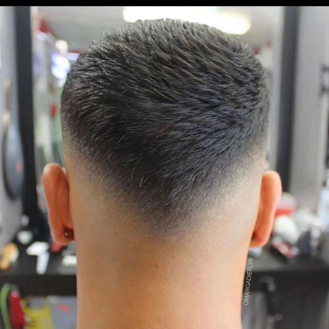 The back of a man 's head with a fade haircut.