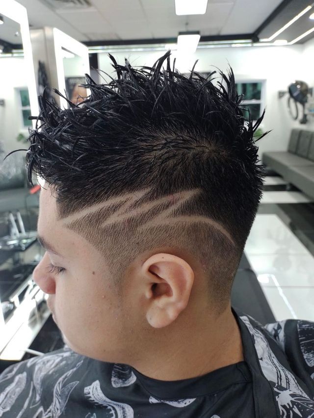 A man is getting his hair cut at a barber shop.