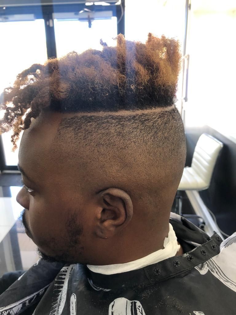 A man is getting his hair cut at a barber shop