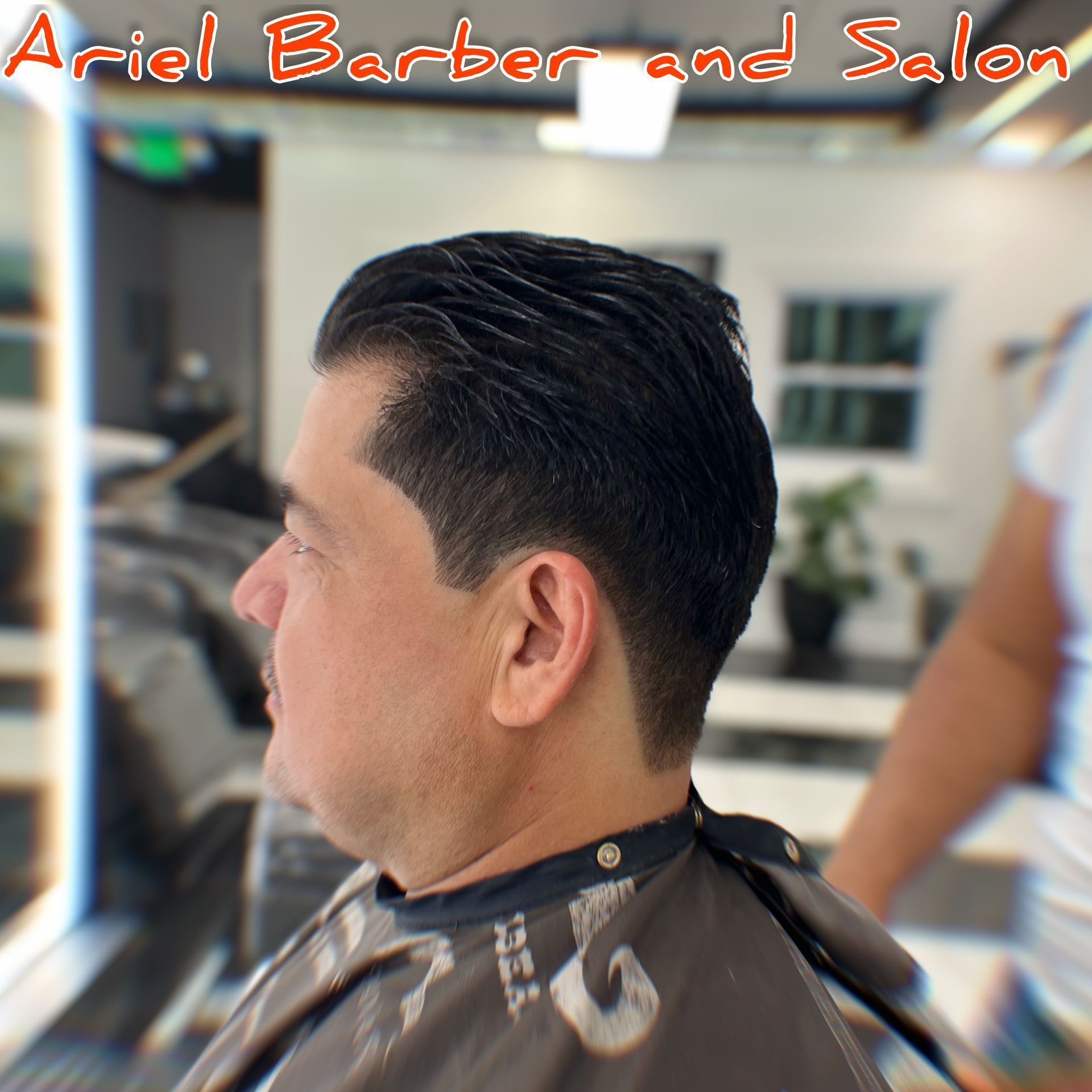 A man is getting his hair cut at the ariel barber and salon