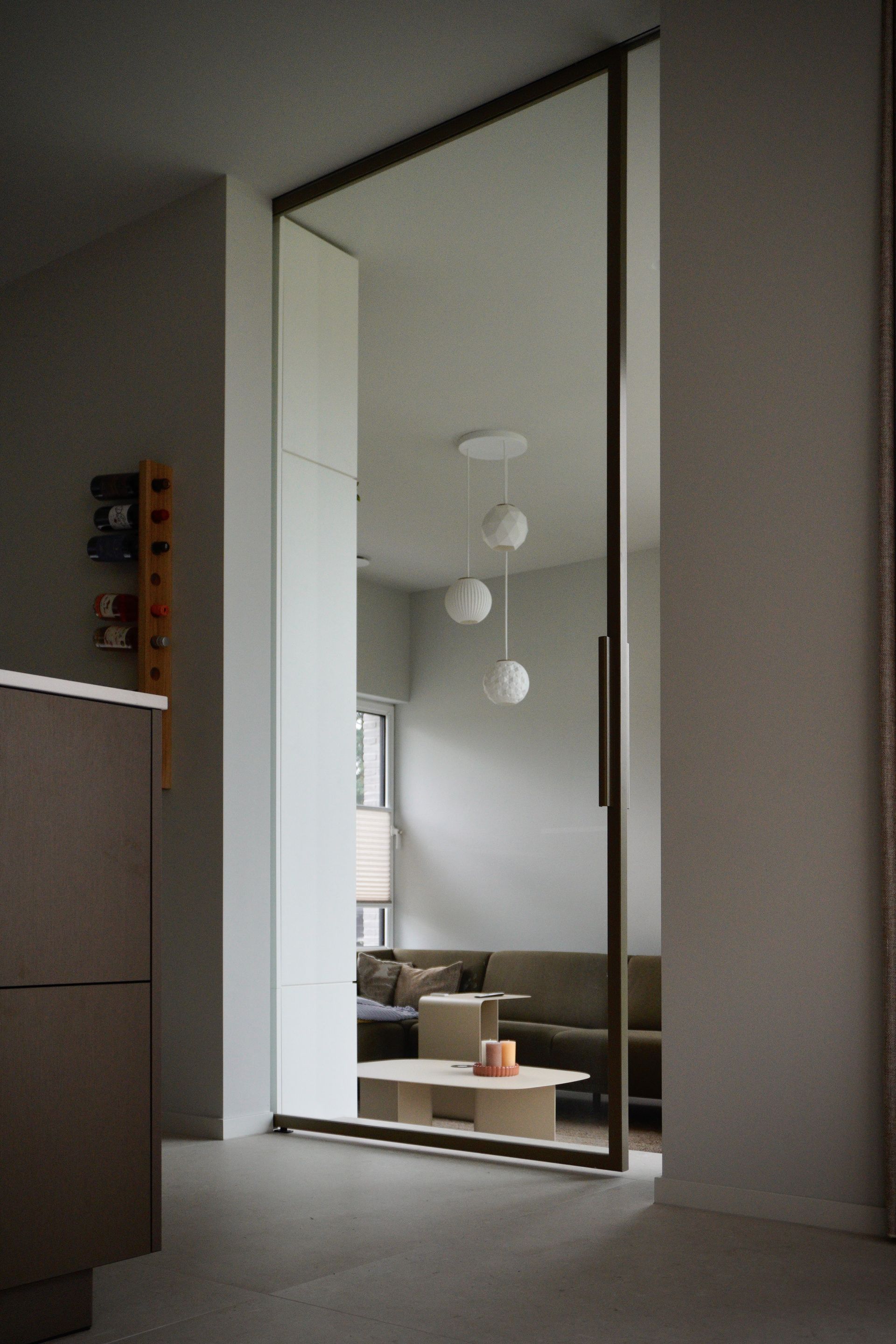 Stalen schuifdeur met een onzichtbaar railsysteem. Brons kleur met helder glas.