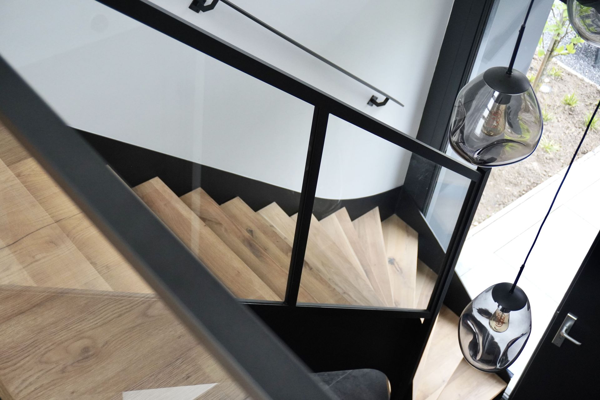 Stalen trap met eikenhouten treden stalen trapleuningen en stalen balustrade met glas