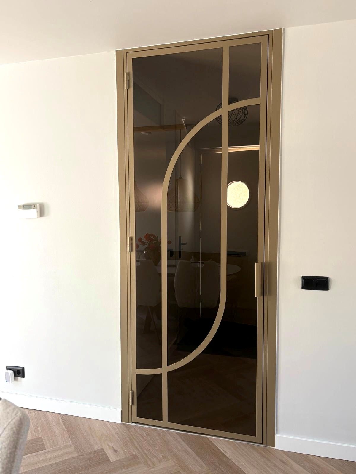Stalen scharnierdeur met glas in een bestaand houten kozijn
