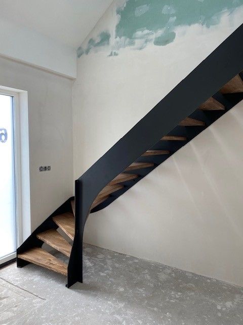 Stalen trap met eikenhouten treden onder kwart