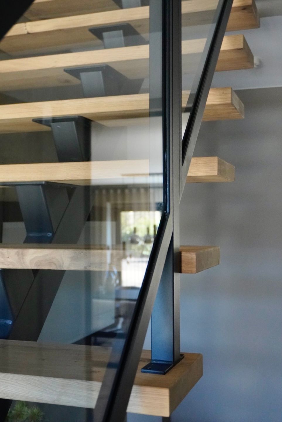 Stalen midden-boom trap met glazen balustrade en eiken treden