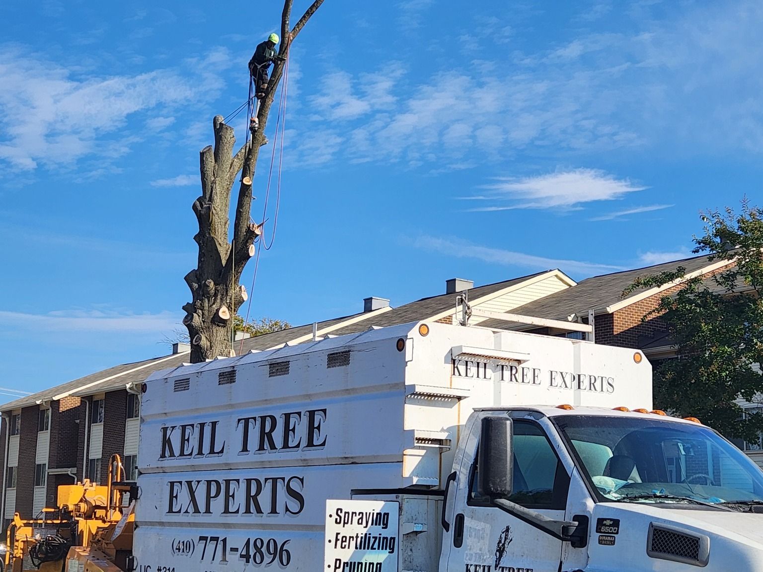 A keil tree experts truck is parked in front of a house.