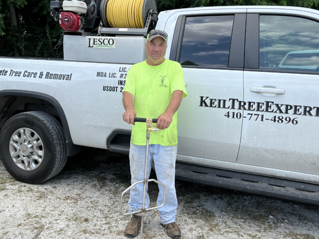 A man in a neon yellow shirt is standing in front of a white truck.