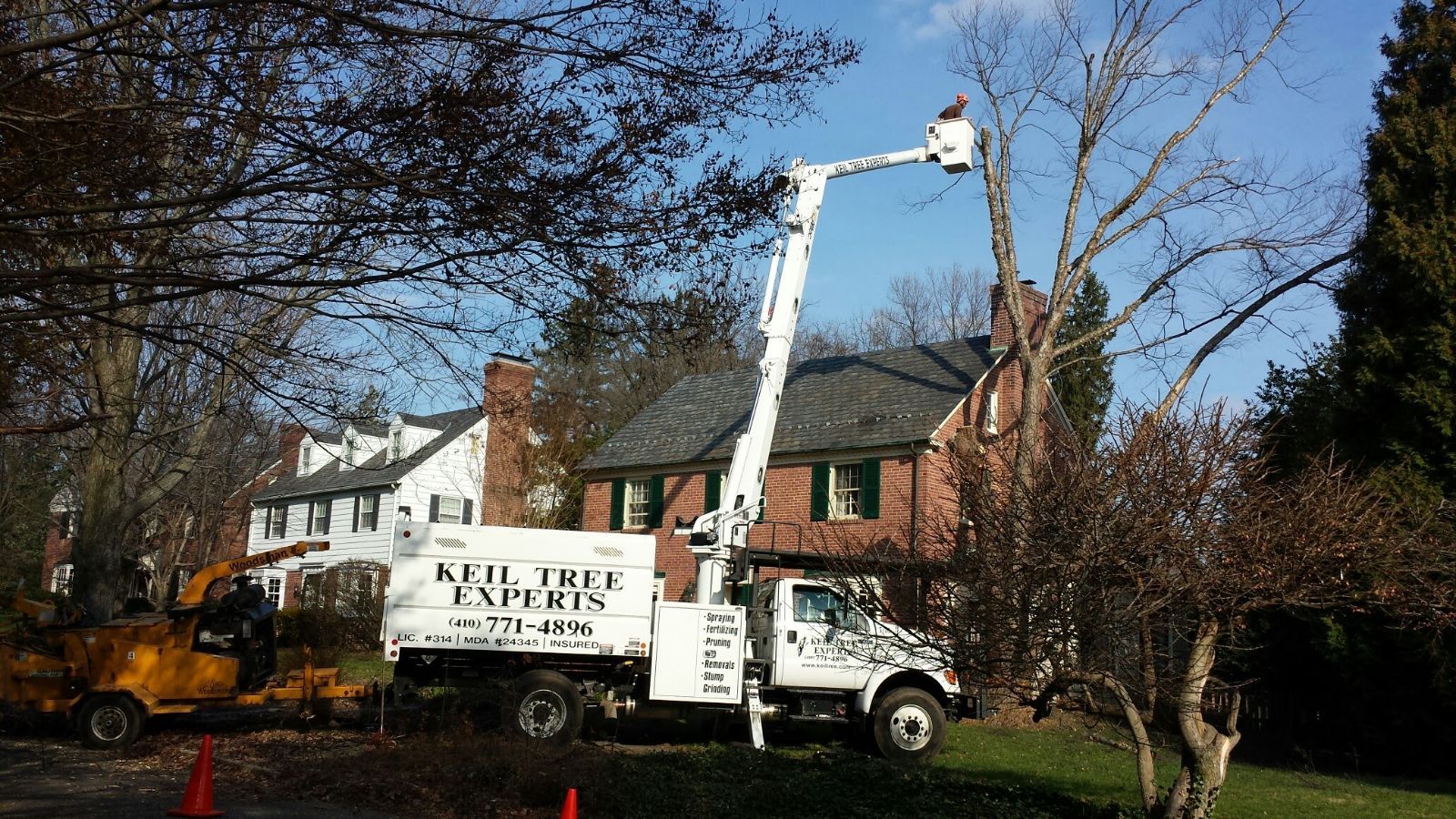 A keil tree experts truck is parked in front of a house