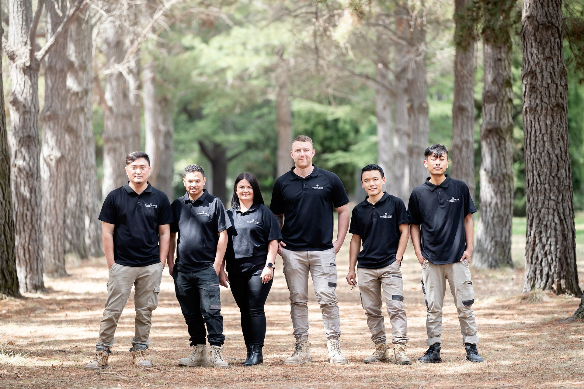 A group of people standing next to each other in a forest.