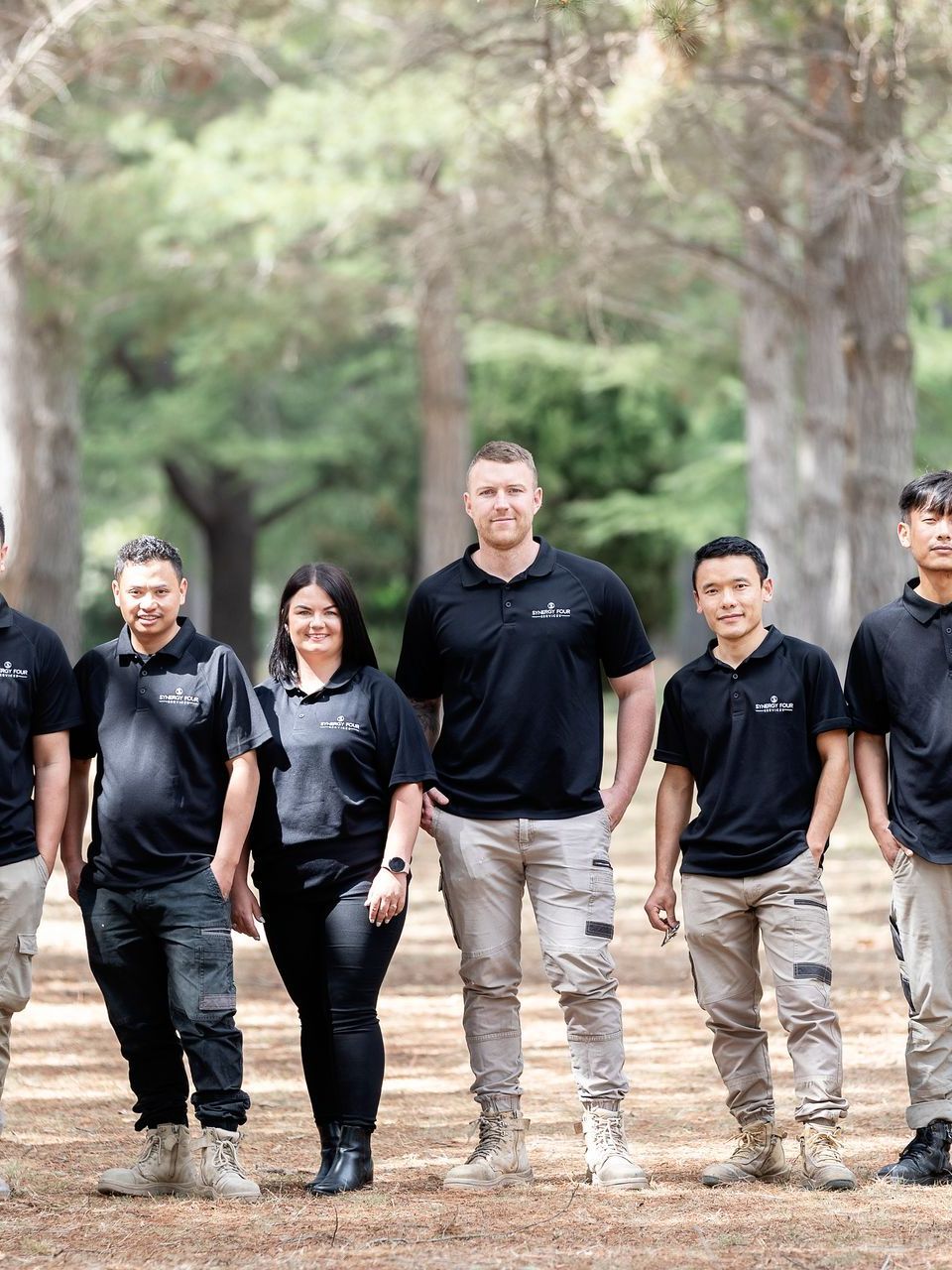 A group of people are standing next to each other in a park.