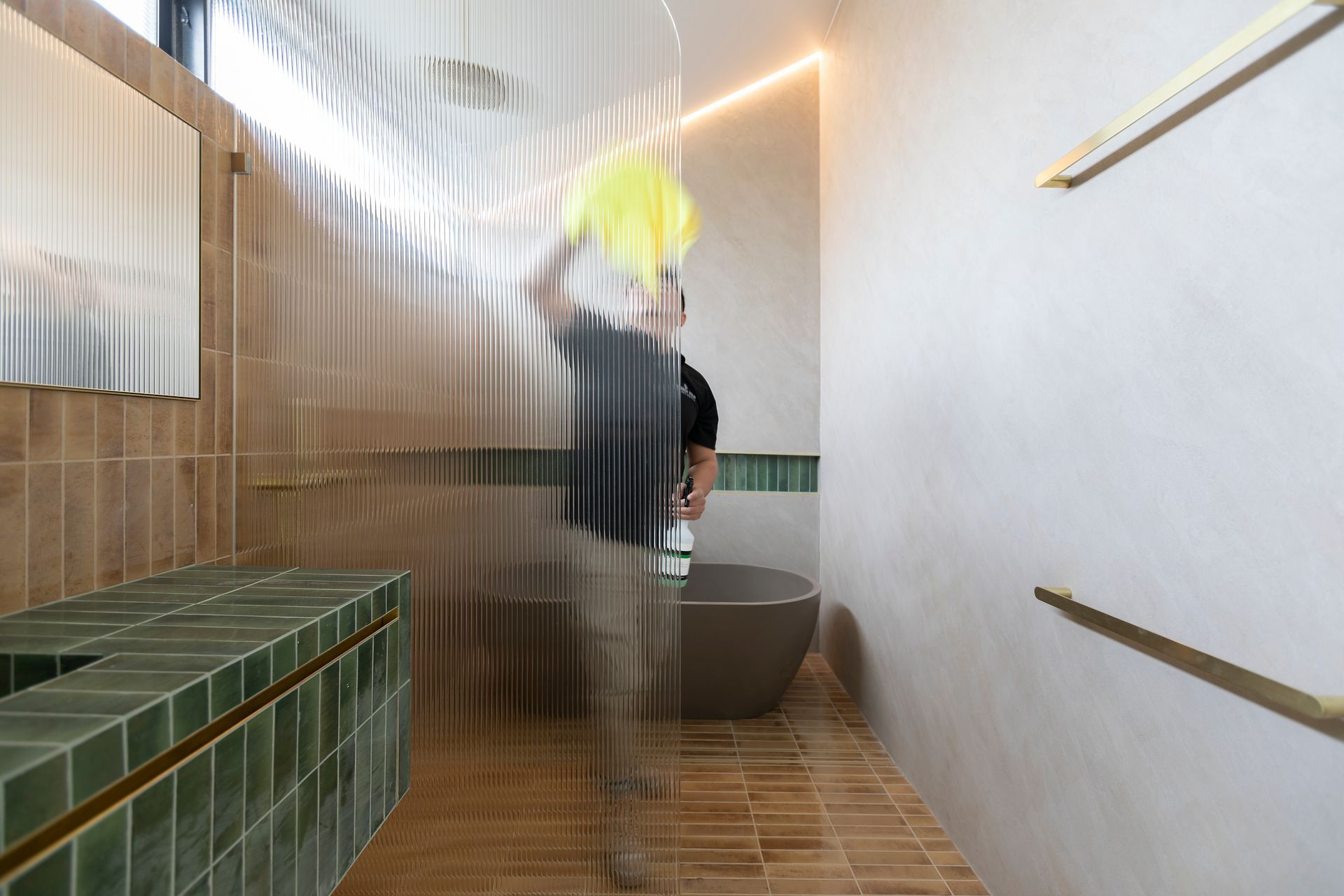 A man is standing in a bathroom behind a shower curtain.