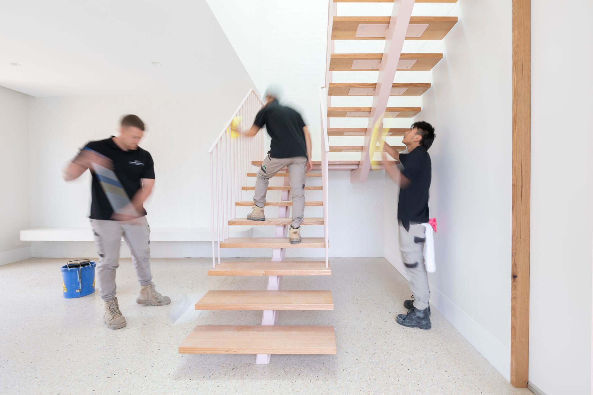 A group of men are cleaning a staircase in a room.