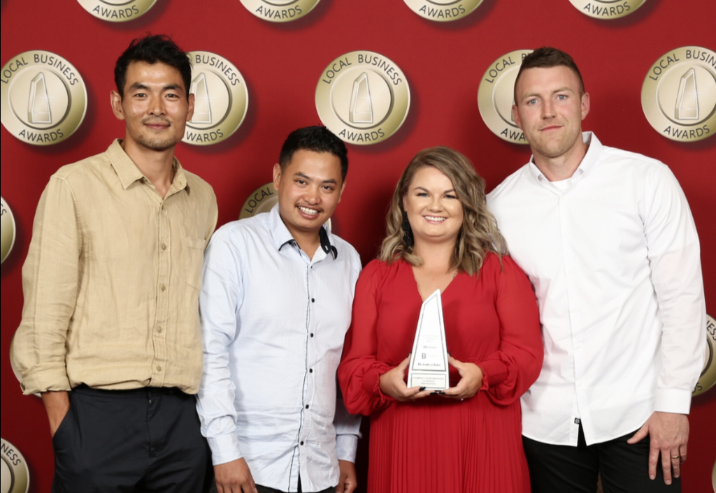 A group of people standing next to each other holding a trophy.