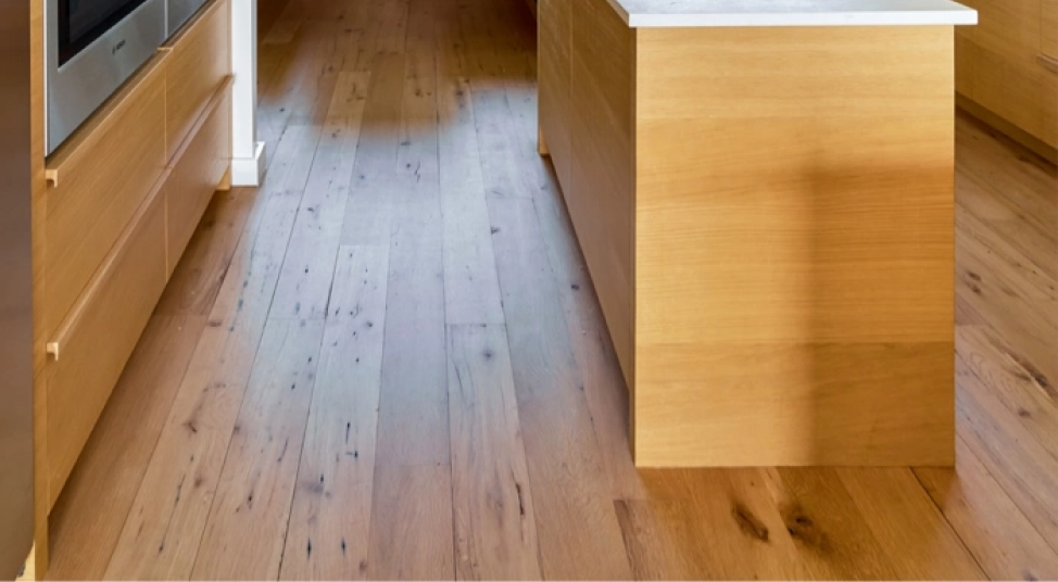 A kitchen with a wooden floor and a wooden island.