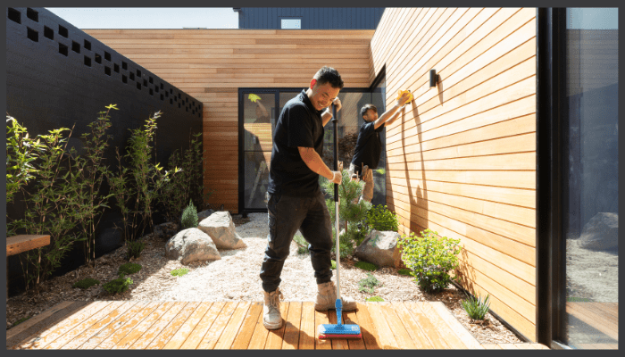 A person is cleaning a wall with a spray bottle and a cloth.