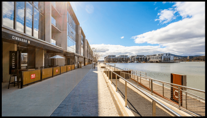 A large building with a lot of windows is next to a body of water.