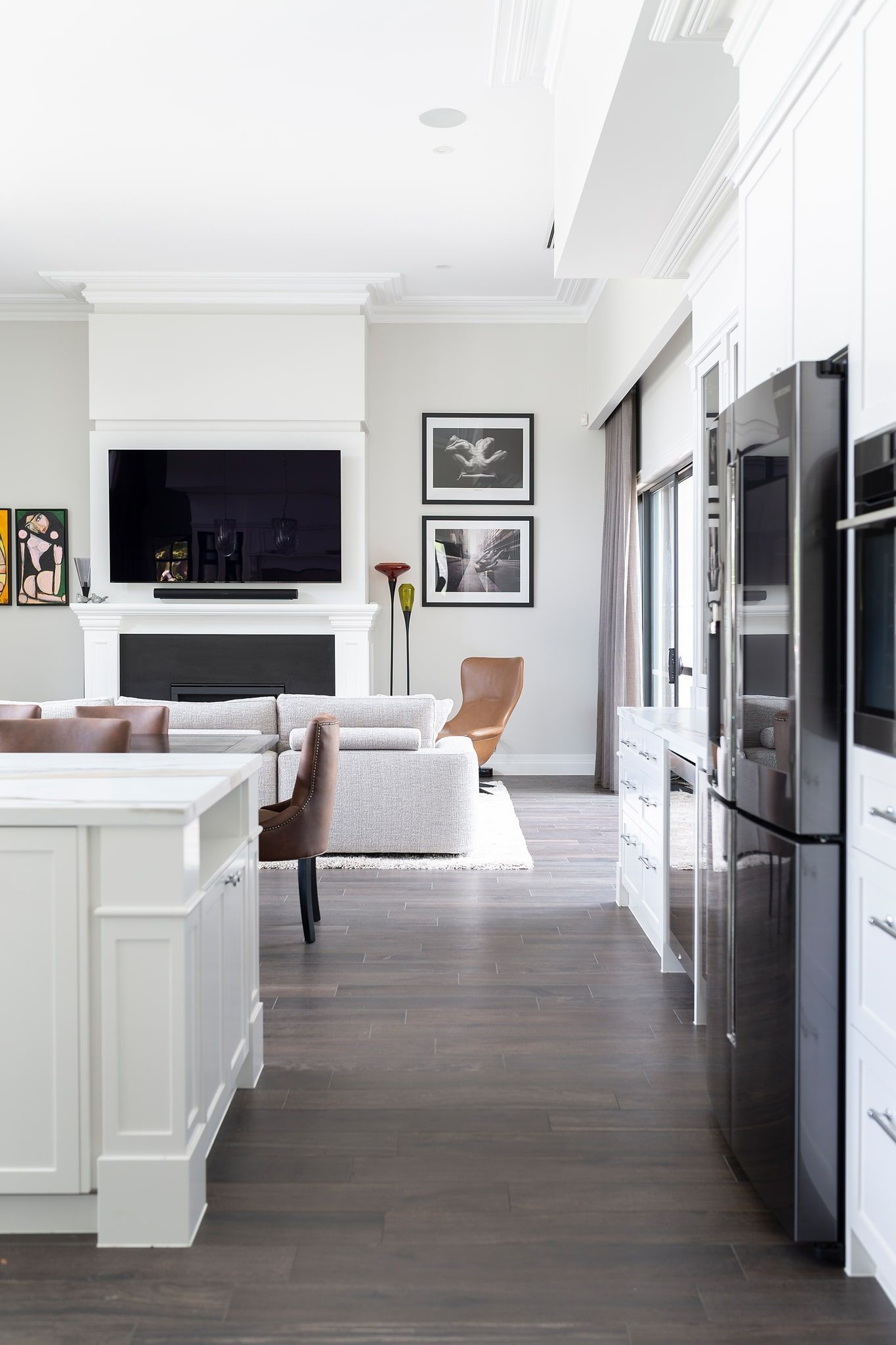 A kitchen with a stainless steel refrigerator and a flat screen tv.