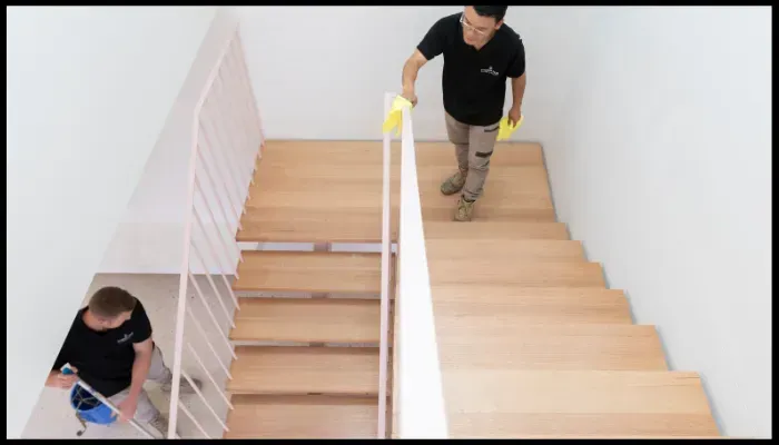 A person is cleaning a wall with a spray bottle and a cloth.