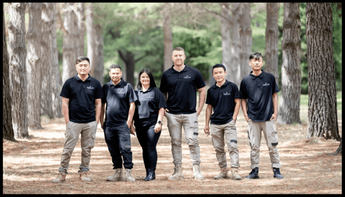 Professional cleaning team in branded uniforms standing outdoors, representing a reliable cleaning company in Canberra.