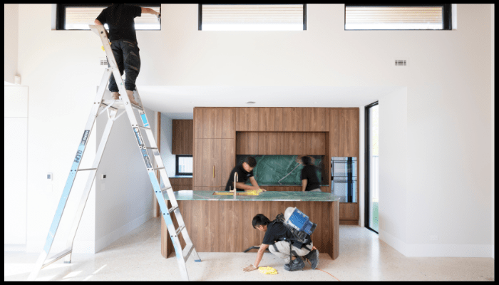Professional residential cleaning team deep cleaning a modern Canberra kitchen, including high windows and stone benchtops