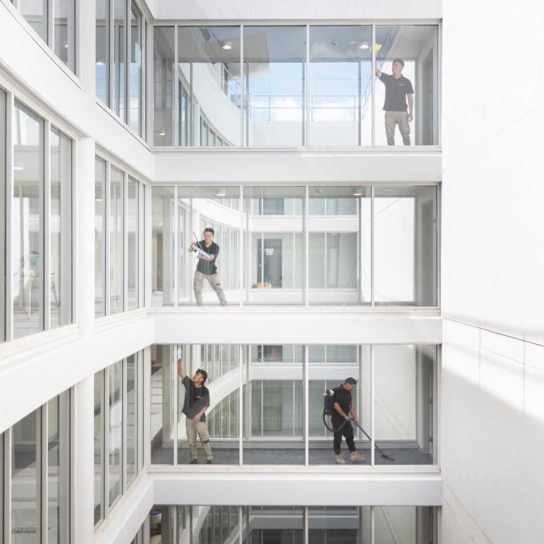 A group of men are standing in a building with lots of windows