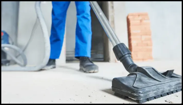 cleaner vacuuming dust and debris on a construction site floor.