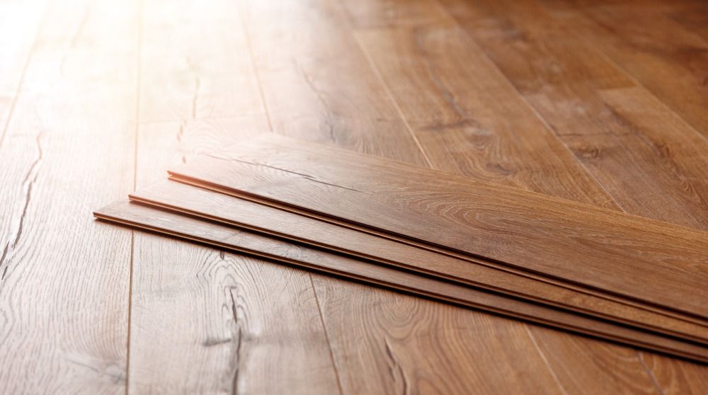 Three pieces of wood are stacked on top of each other on a wooden floor.