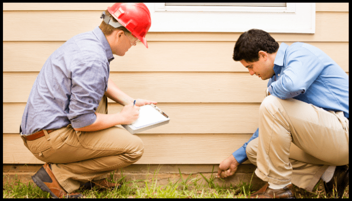 Insurance adjuster and homeowner inspecting exterior water damage and documenting findings for an insurance claim