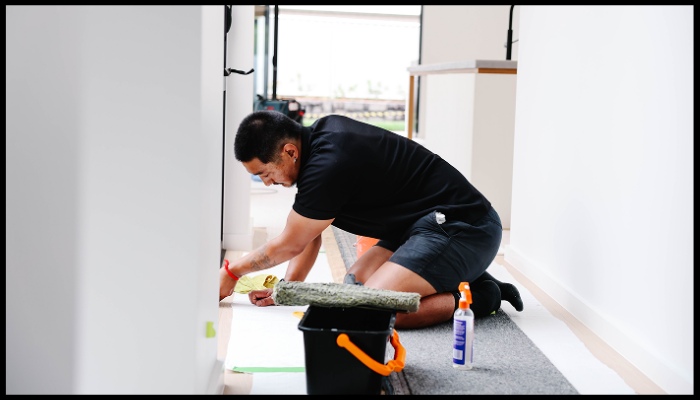 Worker performing detailed post construction cleaning in a newly built interior.
