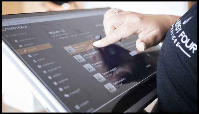 Synergy Four Services staff member using a digital management dashboard for project coordination in a strata property.