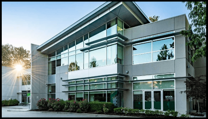 Modern, clean commercial building exterior with glass façade and well-maintained landscaping, illustrating the benefits of professional strata cleaning