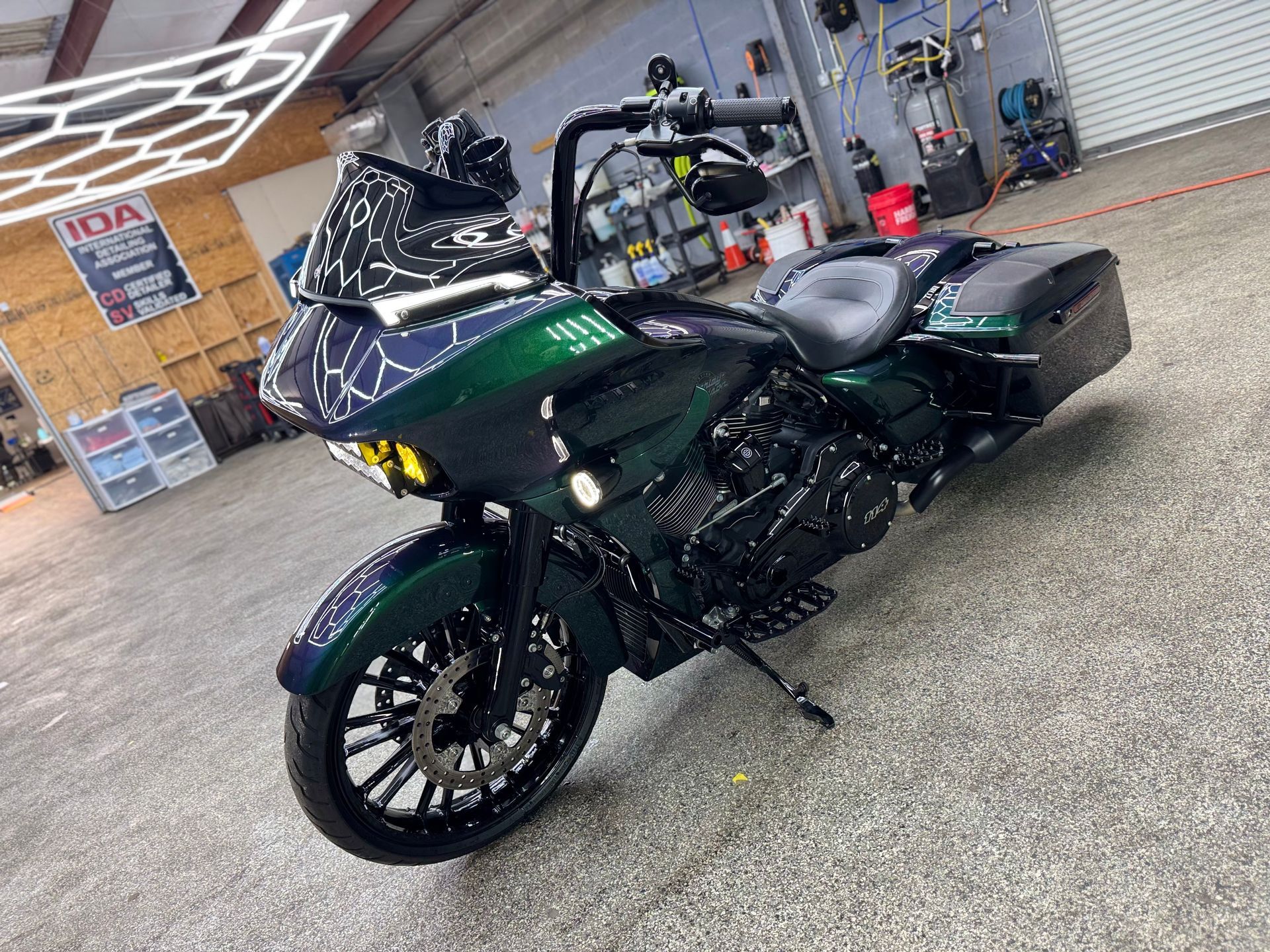 Emerald green custom motorcycle with black accents parked inside a garage.