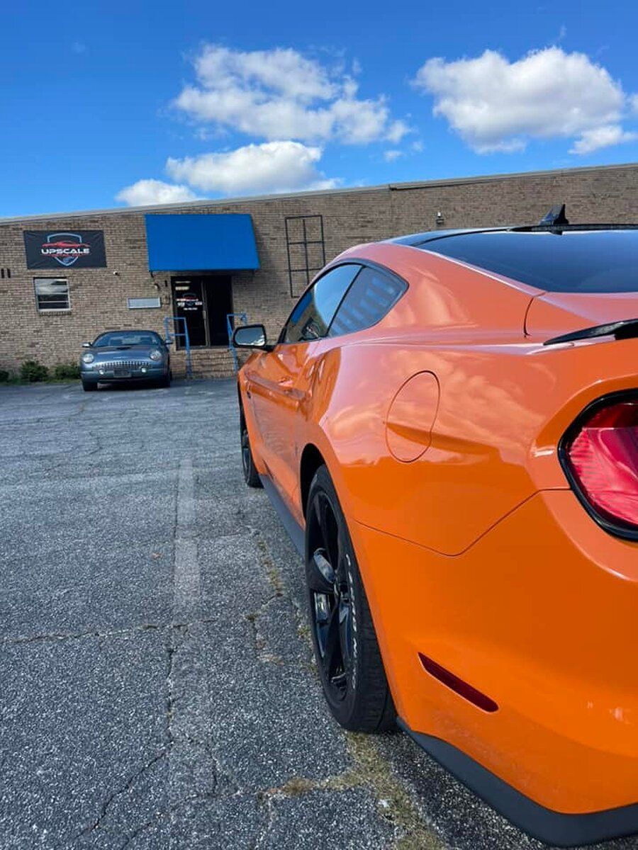 The vibrant orange car, showcasing its smooth ceramic coating